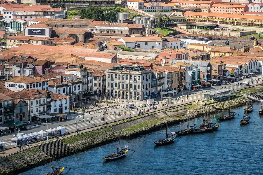 Rabelo boats moored on the Douro river in front of the old riverside warehouses of Porto, Portugal